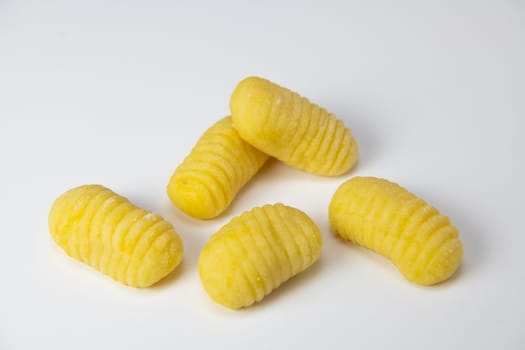 Pile of yellow eggs gnocchi dough dumplings isolated over the white background, High quality photo