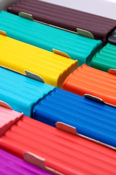 Multi-colored plasticine in a box close-up, background or texture