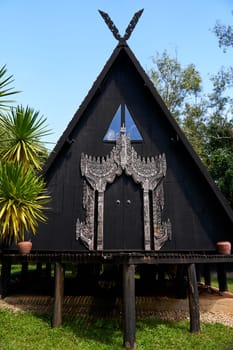 unique and unconventional architecture of buildings on the grounds of the Black Temple in Thailand. The buildings are characterized by their unusual shapes, intricate designs, and dark color scheme.
