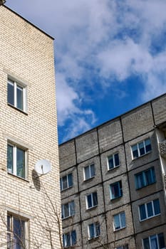 Tall apartment buildings on a blue sky nof with clouds