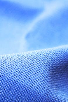 Pleats on blue cotton fabric close up, abstract background