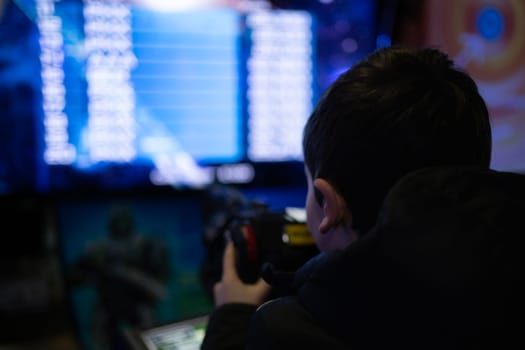 rear low light view of kid playing in a virtual game machine