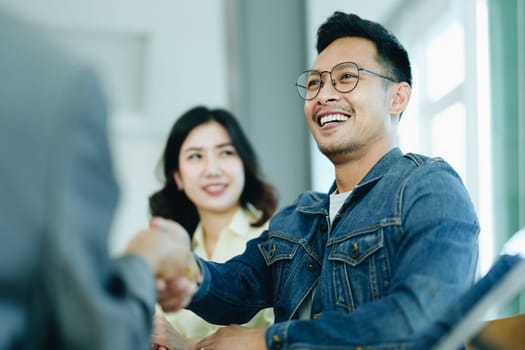 The bank's Mortgage Officers shake hands with customers to congratulate them after signing a housing investment loan agreement.