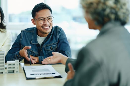 Guarantee Insurance Sign a contract, couple a smiling couple is signing a contract to invest in real estate with the Mortgage officer with the bank.