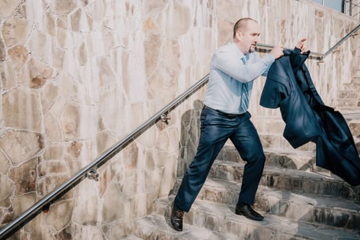 Portrait of a senior professional man in a suit with various problems. A middle-aged businessman with a briefcase descends the stairs.