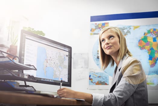 Where should I go next. a young female travel agent working in her office