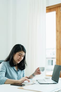 financial, Planning, Marketing and Accounting, portrait of Asian employee checking financial statements using documents and calculators and computer at work..