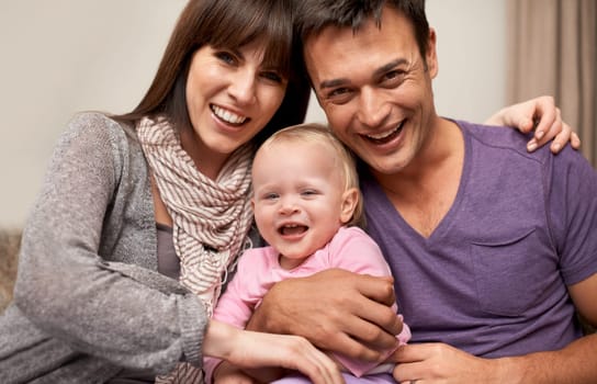 Proud of their daughter. Portrait of a young couple embracing their infant daughter