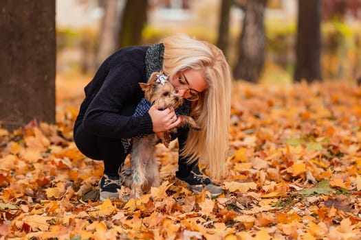 girl with her little dog in autumn park