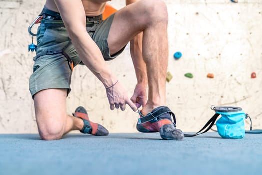 putting on climbing shoes next to the climbing wall. High quality photo