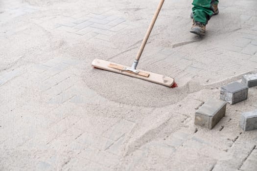 filling the gaps in the new pavement with sand.