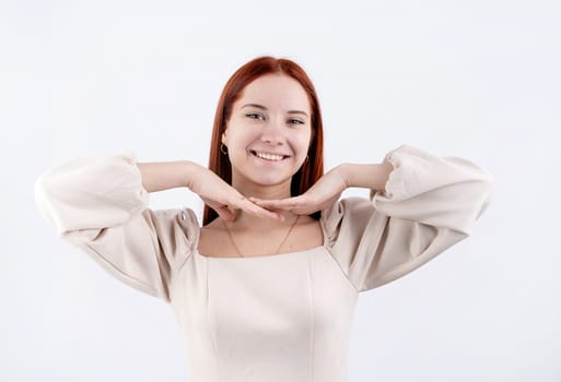 Happy beautiful caucasian woman smiling touching her face over white background, copy space