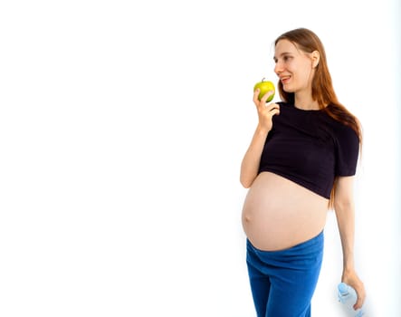 Pregnant woman propose apple for her belly copy space. Beautiful expectant lady having fresh snack, gray studio background. Healthy nutrition and pregnancy concept, copy space. Banner