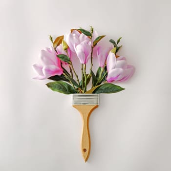 Minimal creative bouquet with flowers and paint brushes for paint. Minimal playful concept of spring and creativity. High quality photo