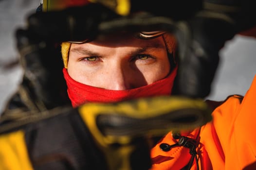male portrait of a handsome male model with beautiful eyes looking at the camera. athlete dressed in gear outdoors, confident look.