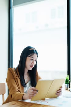 financial, Planning, Marketing and Accounting, portrait of Asian employee checking financial statements using Notebook at work..