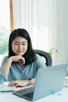 financial, Planning, Marketing and Accounting, portrait of Asian employee checking financial statements using documents and calculators and computer at work..