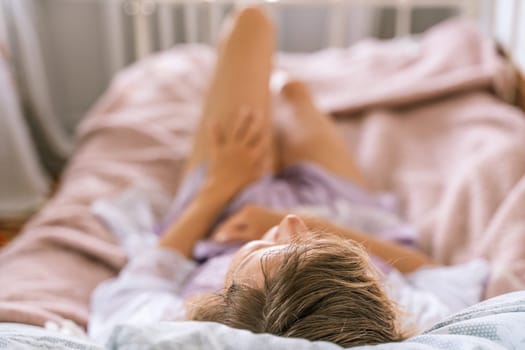 adult beautiful woman sleeping in a purple nightgown in her bed