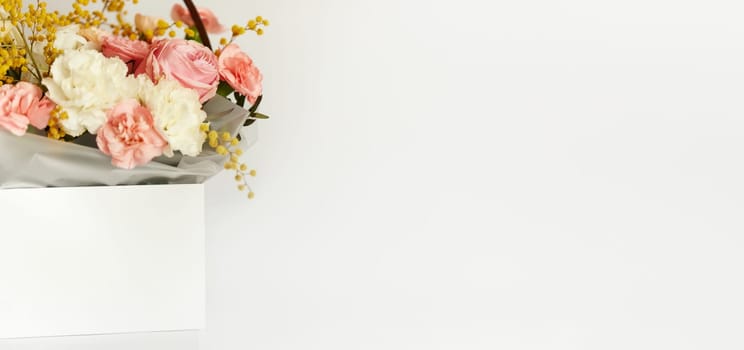 box with beautiful bouquet white and pink flowers on white background. Spring flowers. copy space