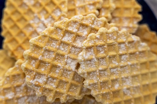 sweet delicious crispy waffles sprinkled with powdered sugar on a plate by the window. Breakfast. Top view