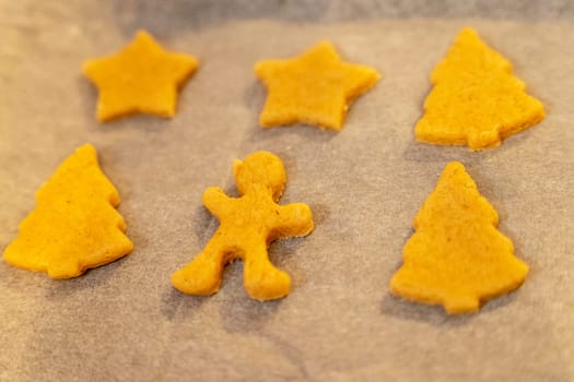 unbaked cookies on a baking sheet from the oven, close-up of various shapes of cookies. figurines, cookies, baking sheet, baking paper. background