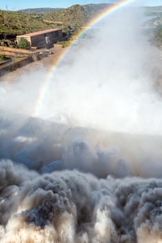 The Gariep Dam overflowing. The dam is the largest in South Africa. It is in the Orange River on the border between the Free State and Eastern Cape Provinces. A rainbow is visible