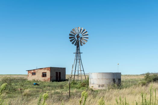 An abandoned farm worker house, windmill and dam next to road S129 between Luckhoff and Fauresmith in the Freestate Province