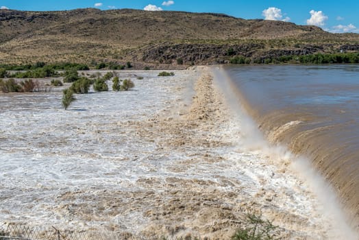 The wall of the Boegoeberg Dam is completely covered by the flooded Orange River