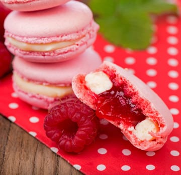 Pink raspberry macaron cookies on dark wooden boards