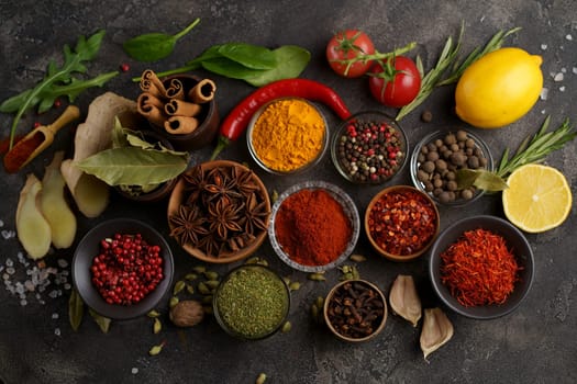 Multicolored herbs and spices for cooking. Indian spices. Against the background of black stone. View from above.