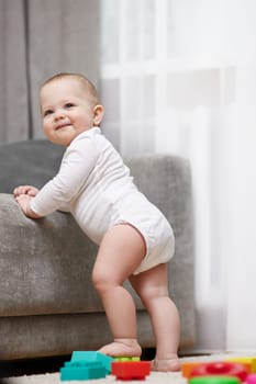 cute baby girl playing with colorful toy blocks at home