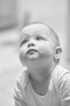 portrait of cute baby girl looks up. black and white