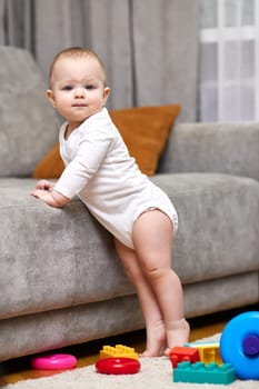 cute baby girl playing with toys at home. Early development for kids.