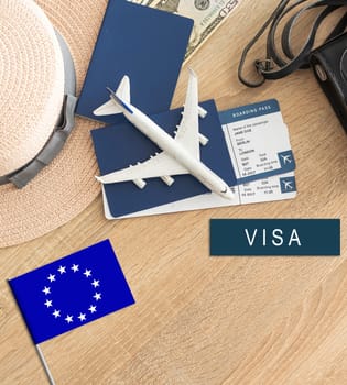 Flag of European Union with passport and toy airplane on wooden background. Flight travel concept.