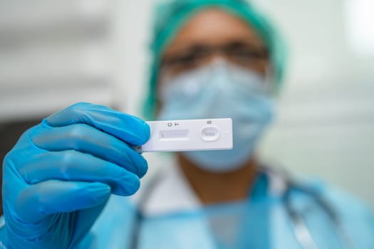 Asian doctor holding Saliva Antigen Test Kit for check Covid19 coronavirus in hospital.