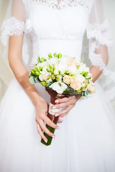 Beautiful wedding bouquet in hands of the bride