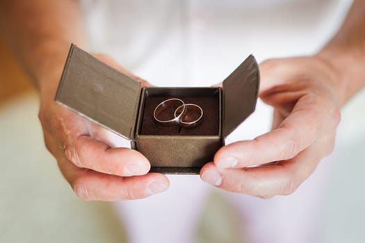 groom holding a beautiful box with wedding rings