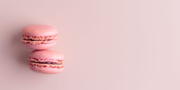 Two pink colored macaroons on pink background. Gift for 8 March, International Women's Day, Valentine Day. Horizontal banner with copyspace