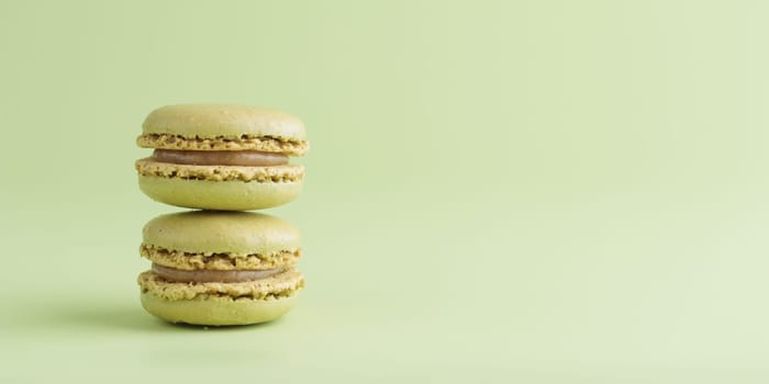 Green pistacio colored macaroons on green background. Gift for 8 March, International Women's Day, Valentine Day. Horizontal banner with copyspace