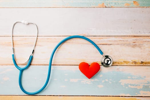 World Health Day. Yellow doctor stethoscope and world globe with Red heart shape on wooden background with copy space, Save world day, Green Earth Environment, Healthcare and medical concept