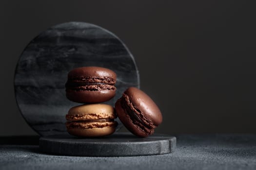 Chocolate eco handmade natural macaroons on dark background in the darkmood style. Horizontal banner top view with a copyspace