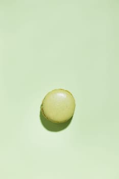 Green pistacio colored macaroon on green background. Gift for 8 March, International Women's Day, Valentine Day. Horizontal banner with copyspace