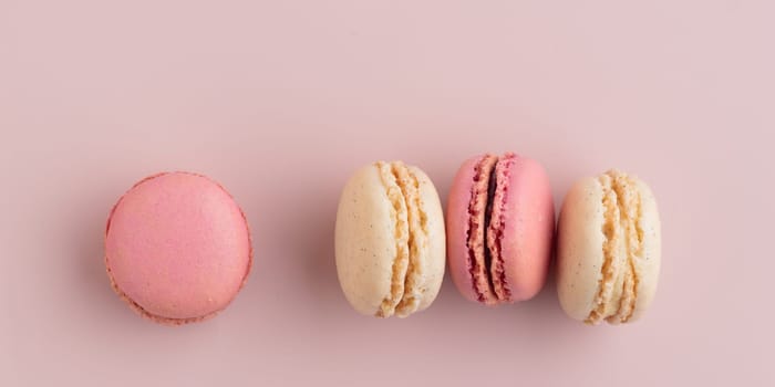 Macaroons on pink background, colorful french cookies pattern. Gift for 8 March, International Women's Day, Valentine Day. Horizontal banner with copyspace