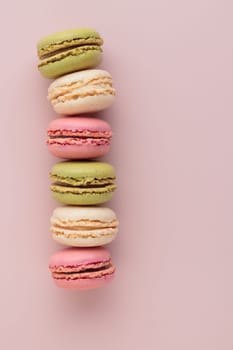 Macaroons on pink background, colorful french cookies pattern. Gift for 8 March, International Women's Day, Valentine Day. Vertical banner with copyspace