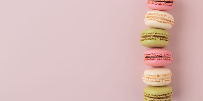 Macaroons on pink background, colorful french cookies pattern. Gift for 8 March, International Women's Day, Valentine Day. Horizontal banner with copyspace