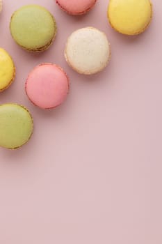 Macaroons on pink background, colorful french cookies pattern. Gift for 8 March, International Women's Day, Valentine Day. Vertical banner with copyspace