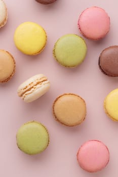 Macaroons on pink background, colorful french cookies pattern. Gift for 8 March, International Women's Day, Valentine Day. Vertical