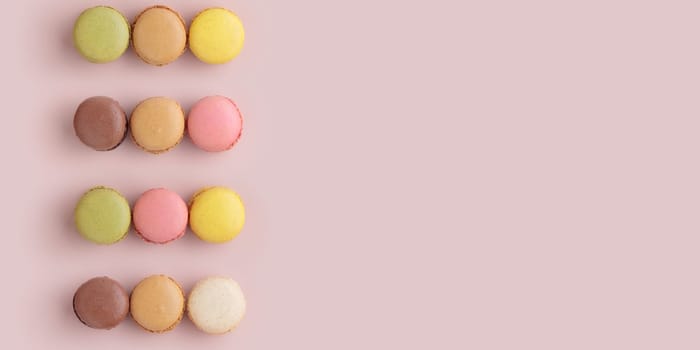 Macaroons on pink background, colorful french cookies pattern. Gift for 8 March, International Women's Day, Valentine Day. Horizontal banner with copyspace