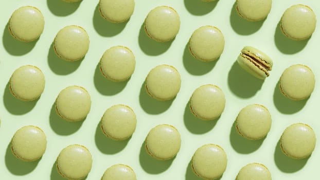Green pistacio macaroons on green background, colorful french cookies pattern. Gift for 8 March, International Women's Day, Valentine Day. Horizontal banner
