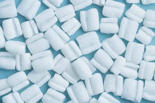 Styrofoam granules for filling boxe - reliable protective packaging solution, environmental friendly, fireproof and durable, shock-absorbing filler on a blue background